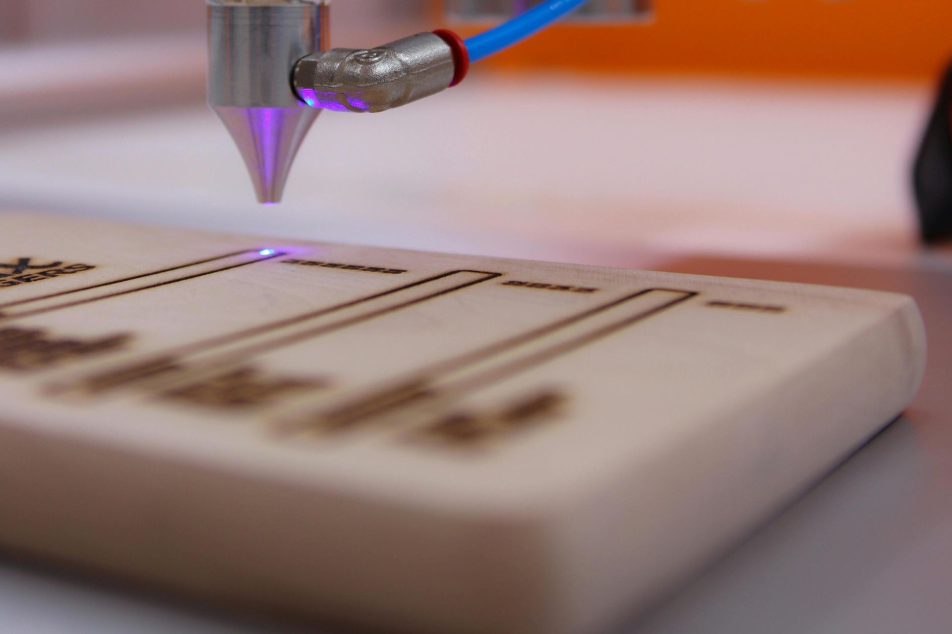 High-tech laser engraving machine working on wooden surface.